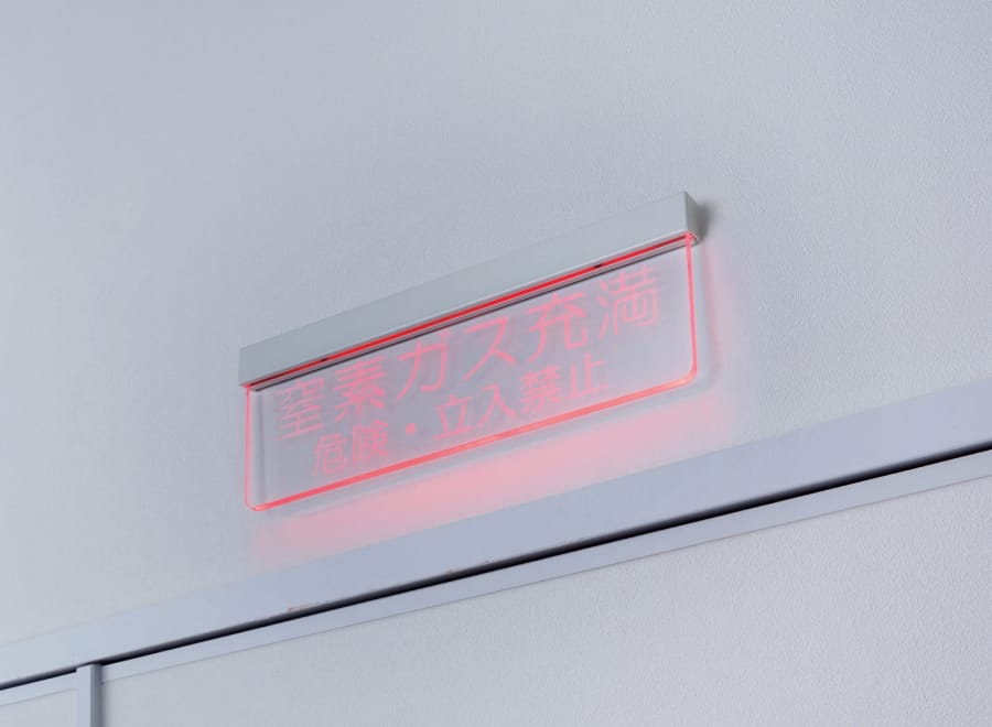 「窒素ガス充満 危険・立入禁止」と日本語で書かれた、透明でスリムなデザインの表示灯。