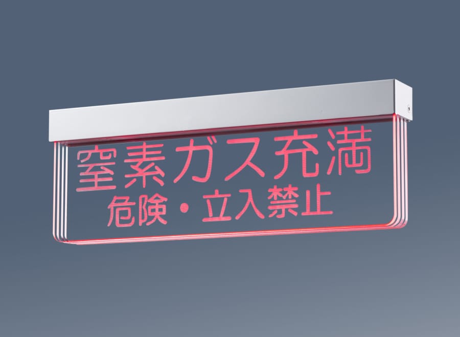 暗闇の中で点灯している、透明な表示灯「LuxCi」。表示板の文字が赤く光り、「窒素ガス充満 危険・立入禁止」と書いている。